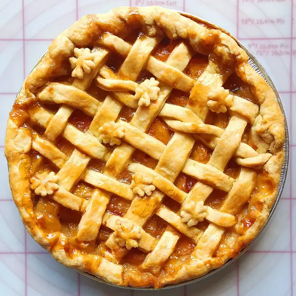 blue ribbon peach pie with hand decorated latice pie crust